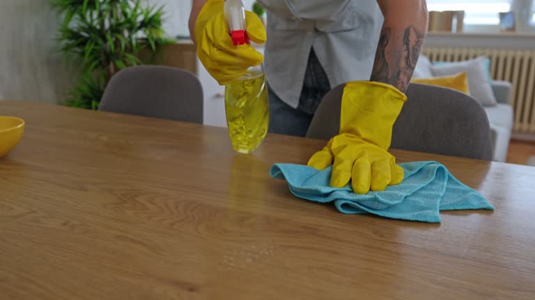 Professional cleaner wiping office desk